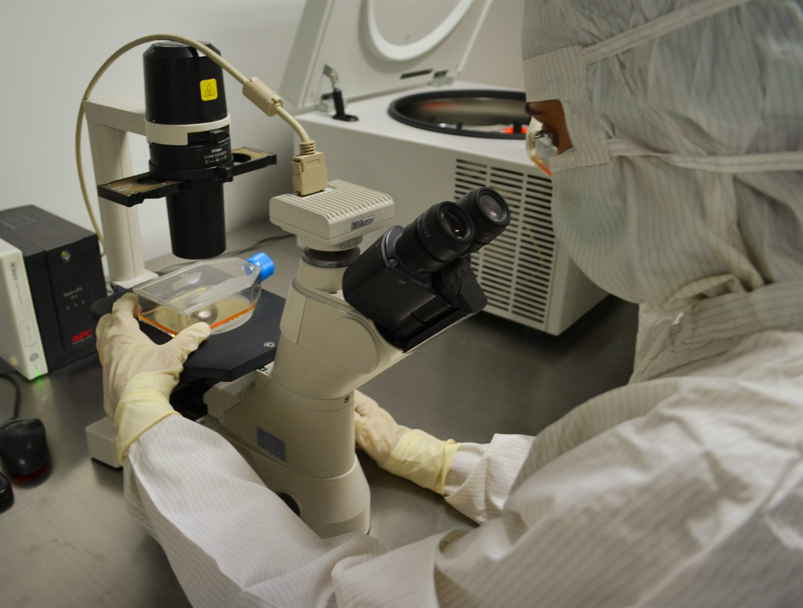 A research professional works with equipment in a laboratory.